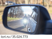 Dazzle lighting from riding motorcycle in side view mirror of car. Dazzling effect concept. Стоковое фото, фотограф Кекяляйнен Андрей / Фотобанк Лори