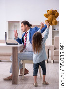Girl bothering young father during working from house in pandemi. Стоковое фото, фотограф Elnur / Фотобанк Лори