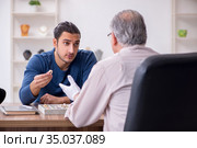 Young man visiting old male jeweler. Стоковое фото, фотограф Elnur / Фотобанк Лори