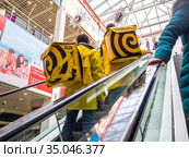 Курьеры службы доставки "Яндекс.Еда"  поднимаются на эскалаторе (2020 год). Редакционное фото, фотограф Вячеслав Палес / Фотобанк Лори
