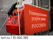 Телефонный автомат в вестибюле станции Маяковская московского метрополитена с баннером с надписью "Универсальные услуги связи. Россвязь" в городе Москве, Россия (2020 год). Редакционное фото, фотограф Николай Винокуров / Фотобанк Лори