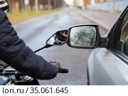 Motorcycle rider touching side mirror of a car when riding nearby on a road, close up view. Стоковое фото, фотограф Кекяляйнен Андрей / Фотобанк Лори