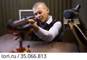 Man zeroing hunting rifle from bench rest in shooting range. Стоковое фото, фотограф Яков Филимонов / Фотобанк Лори