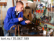 Gunsmith assembling smallbore sporting pistol in workshop. Стоковое фото, фотограф Яков Филимонов / Фотобанк Лори