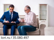 Young male lawyer visiting old man in testament concept. Стоковое фото, фотограф Elnur / Фотобанк Лори