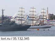 Парусник "Херсонес" проходит рядом с кораблём-разведчиком "Иван Хурс" на параде в честь Дня ВМФ в городе- герое Севастополе, Крым (2020 год). Редакционное фото, фотограф Николай Мухорин / Фотобанк Лори