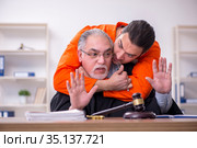 Old male judge meeting with young captive in courthouse. Стоковое фото, фотограф Elnur / Фотобанк Лори
