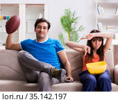 Man watching americal football with his wife. Стоковое фото, фотограф Elnur / Фотобанк Лори