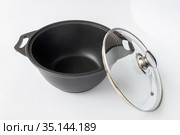 Black cast iron pan on the light background. Стоковое фото, фотограф Володина Ольга / Фотобанк Лори
