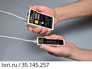 Руки мастера проверяют LAN тестером обжатый провод для компьютерной сети (2017 год). Редакционное фото, фотограф Максим Мицун / Фотобанк Лори