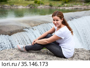 Portrait of attractive woman sitting close to waterfall of the Cijevna river. It is called Montenegrin Niagara Falls. Surroundings of Podgorica city. Montenegro, Europe. Стоковое фото, фотограф Кекяляйнен Андрей / Фотобанк Лори