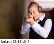 Confident shooter sighting in or zeroing shotgun in shooting gallery. Стоковое фото, фотограф Яков Филимонов / Фотобанк Лори