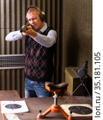 Focused man aiming shotgun at target in shooting range. Стоковое фото, фотограф Яков Филимонов / Фотобанк Лори