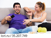 Woman trying to take away TV remote from boyfriend. Стоковое фото, фотограф Яков Филимонов / Фотобанк Лори