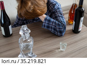 woman surrounded by bottles of alcohol - concept of female alcoholism. Стоковое фото, фотограф Володина Ольга / Фотобанк Лори