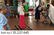 Russian women are on toddler baptism in church, godmother with goddaughter, mother with teenager daughter. Ceremony of sacrament of initiation into the Christian (2021 год). Редакционное видео, видеограф Кекяляйнен Андрей / Фотобанк Лори