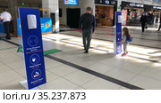 Dispenser with antibacterial gel is in the Antalya International airport. Signs with notification about keeping social distance, washung hands and using mask. Turkey (2021 год). Редакционное видео, видеограф Кекяляйнен Андрей / Фотобанк Лори