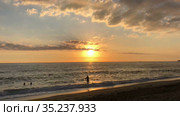 Timelapse of sandy sunset Kleopatra beach with silhouettes of people enjoying sea and sun. It is urban sandy beach is close to mountain with the Alanya castle, Turkey (2021 год). Стоковое видео, видеограф Кекяляйнен Андрей / Фотобанк Лори