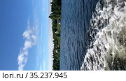 Vertical video, side view from the motor boat floating on lake. Village with timber houses is on lakeshore. Стоковое видео, видеограф Кекяляйнен Андрей / Фотобанк Лори
