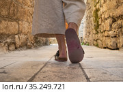 Detail shot of female legs wearing comfortable travel sandals walking on old medieval cobblestones street dring sightseeing city tour. Travel, tourism and adventure concept. Стоковое фото, фотограф Matej Kastelic / Фотобанк Лори