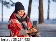 Young woman using smart phone shooting winter landscape in frost forest. Стоковое фото, фотограф Кекяляйнен Андрей / Фотобанк Лори