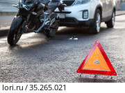 Rear-end collision on a road, suv car hits a motorcycle, emergency warning triangle is on asphalt roadside. Стоковое фото, фотограф Кекяляйнен Андрей / Фотобанк Лори