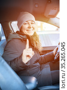 Adult female driver gesturing with forefinger before driving a car, woman wearing winter clothes. Стоковое фото, фотограф Кекяляйнен Андрей / Фотобанк Лори