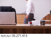 Young male employee stapling paper in the office. Стоковое фото, фотограф Elnur / Фотобанк Лори