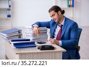 Young male bookkeeper calculating expences. Стоковое фото, фотограф Elnur / Фотобанк Лори