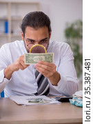 Young male bookkeeper in counterfeit bills concept. Стоковое фото, фотограф Elnur / Фотобанк Лори