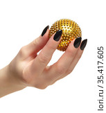 Female hand with black nails manicure and golden spiked massage ball in fingers. Стоковое фото, фотограф Сергей Пристяжнюк (Serg Zastavkin) / Фотобанк Лори