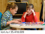 Девочка объясняет другой девочке как играть в настольную игру. Стоковое фото, фотограф Иванов Алексей / Фотобанк Лори