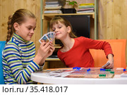 Дети играют в настольную игру, одна из девочек подглядывает карты другой. Стоковое фото, фотограф Иванов Алексей / Фотобанк Лори