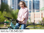 Blond teenage girl sitting on her blue bicycle, portrait outdoor. Стоковое фото, фотограф Кекяляйнен Андрей / Фотобанк Лори