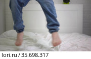 The boy jumps on bed having fun rejoicing carefree childhood Fun joy home in room.Happy family children.School holidays. Purchase of a new apartment. Splashing out energy, relaxing in the apartment. Стоковое видео, видеограф Ирина Ткачук / Фотобанк Лори