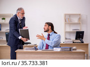 Old male boss and young employee working in the office. Стоковое фото, фотограф Elnur / Фотобанк Лори