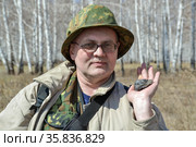 Мужчина держит в руке фрагмент Челябинского метеорита, найденного  весной 2013 года недалеко от города Чебаркуль. Стоковое фото, фотограф Александр Бушков / Фотобанк Лори
