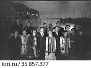 Коллективный портрет с актёрами Театра одетыми в национальную якутскую одежду, мужчины в костюмах позирует рядом с театралами на фоне полотна с изображением реки и гор, Якутия. Редакционное фото, фотограф Варфоломей Тетерин / Фотобанк Лори