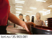 School cafeteria worker serves noodles to students. Стоковое фото, агентство Ingram Publishing / Фотобанк Лори