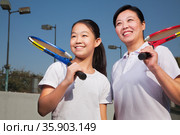 Mother and daughter playing tennis . Стоковое фото, агентство Ingram Publishing / Фотобанк Лори