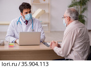 Old male patient visiting young male doctor in vaccination conce. Стоковое фото, фотограф Elnur / Фотобанк Лори