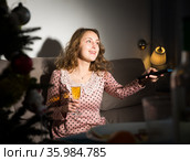 Happy young woman watching TV on Christmas night. Стоковое фото, фотограф Яков Филимонов / Фотобанк Лори