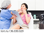 Cosmetologist planning upcoming lip reshaping procedures for female patient. Стоковое фото, фотограф Яков Филимонов / Фотобанк Лори