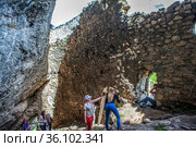 Туристы в дзивгисской наскальной крепости. Село Дзивгис. Алагирский район. Северная Осетия. Россия (2021 год). Редакционное фото, фотограф Сергей Афанасьев / Фотобанк Лори