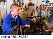 Gunsmith assembling smallbore sporting pistol in workshop. Стоковое фото, фотограф Яков Филимонов / Фотобанк Лори