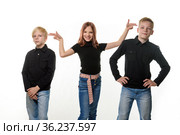 Счастливые дети на белом фоне, девочка приставила импровизированные пистолеты к головам братьев. Стоковое фото, фотограф Иванов Алексей / Фотобанк Лори