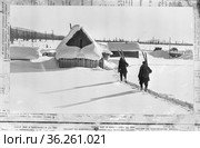 Фотография с двумя геологами идущими по снегу лежит на газете, участники Тимптоно-Учурской экспедиции шагают по узкой вытоптанной в снегу тропинке, Якутия. Редакционное фото, фотограф Варфоломей Тетерин / Фотобанк Лори
