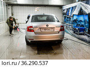 Мойщик покрывает пеной автомобиль на мойке (2021 год). Редакционное фото, фотограф Игорь Низов / Фотобанк Лори