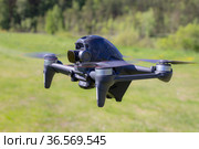 Moscow, 31 MAY 2021 : A new DJI FPV drone is flying during a sunny day on grass in beckground. Top Front View. Headless Quadcopter with Digital 4K 60 fps Hasselblad Camera and Remote Control. Стоковое фото, фотограф Алексей Ширманов / Фотобанк Лори