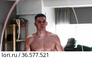 Gym training - shirtless young man jumping over the rope on the spot. Стоковое видео, видеограф Константин Шишкин / Фотобанк Лори